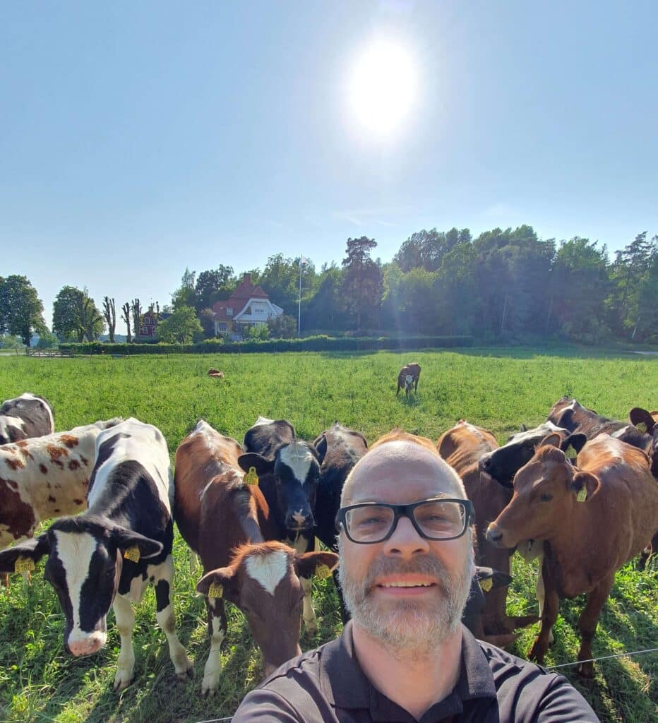 Farmer with a field of Cows in the background